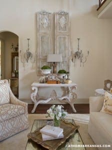 White console table with ornate detailing and sconces.