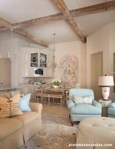 Cream-colored kitchen with exposed wooden beams and light blue seating.