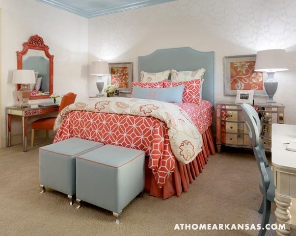 Bedroom with blue and white bedding, mirror, and dresser.