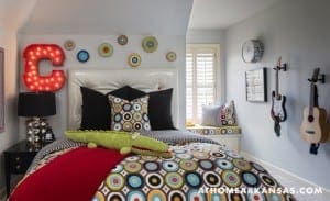 Blue bedroom with patterned bedding, guitar, and decorative elements.
