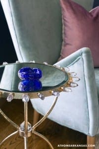 Blue glass sculpture on a mirrored table with crystal accents.