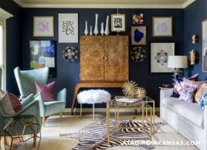 Dark blue wall with framed artwork and furniture.