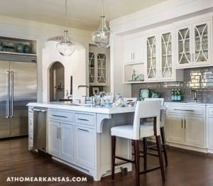 White kitchen island with gray cabinets and marble countertop.