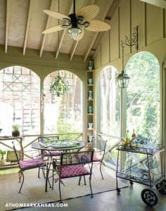 Sunroom with arched windows, a table, and bar cart.