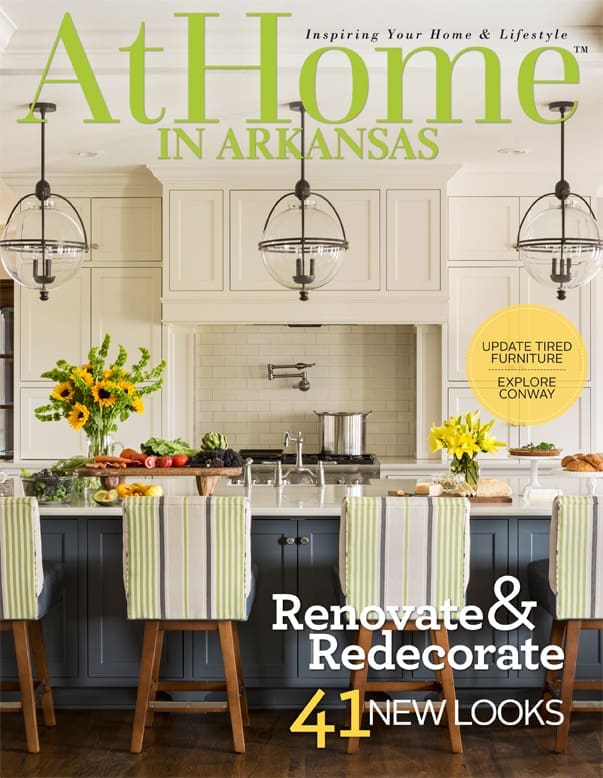 At Home magazine cover featuring a kitchen with globe pendants and striped chairs.