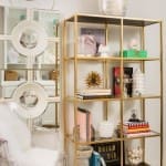 Gold shelving unit with decorative objects and books.