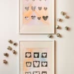 Two framed watercolor prints with silver heart motifs and geometric cubes.