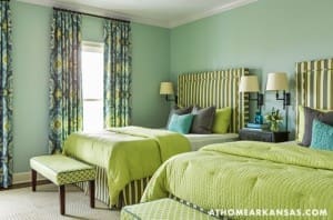 Green bedroom with striped headboard, lime green bedding, and patterned curtains.
