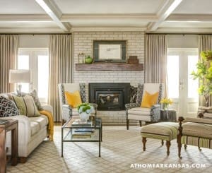 Living room with brick fireplace, sofa, and patterned rug.