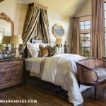 Master bedroom with a large bed, ornate mirror, and window view.