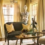 Gold-toned sofa with patterned pillows in a sunlit room.
