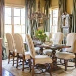 Dining room with a dark wood table, chairs, and a large chandelier.
