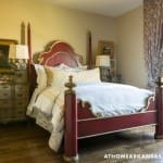 Red and gold four-poster bed with ornate detailing.
