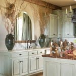 Light green kitchen island with wooden cabinetry and a marble sink.