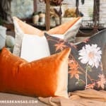 Orange, gray, and white decorative pillows on a sofa.