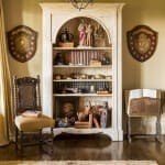 Tall, arched bookcase with shields and figurines.