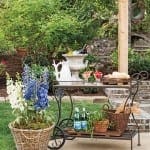 Outdoor bar cart with wine, bread, and flowers.