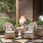 Stone exterior with seating area, potted plants, and walkway.