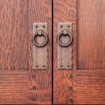 Dark wood cabinet doors with bronze ring pulls.