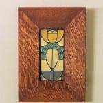 Wooden frame with a stained glass insect design.