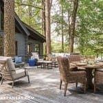 Deck with outdoor furniture and a stone fireplace.