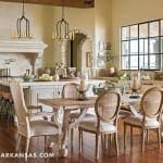 Large kitchen with stone fireplace, island, and wooden chairs.