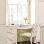 White kitchen window seat with patterned wallpaper and chair.
