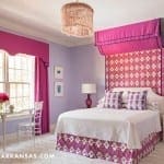 Purple bedroom with pink accents, patterned headboard, and window.