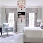 Master bedroom with patterned drapes, chandelier, and gray walls.