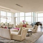 Large living room with a piano, sofa, and city view.