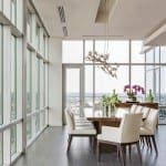 White dining room with large windows and a chandelier.