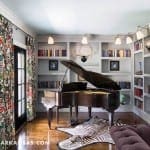 Gray room with piano, bookshelves, and zebra rug.