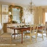 Formal dining room with a long wooden table, chairs, and a large ornate chandelier.