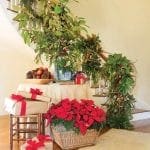Hallway decorated with greenery, poinsettias, and gifts.