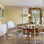 Cream-colored dining room with a wooden table, chairs, and a sideboard.