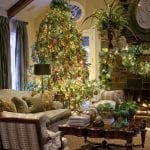 Large Christmas tree in a living room with a fireplace.