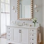White vanity with marble countertop and silver fixtures.