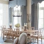 Blue patterned drapes, wooden dining table, and chairs in a formal dining room.
