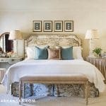 Master bedroom with a large, upholstered bed and dresser.