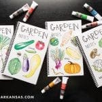Four garden notes notebooks with watercolor illustrations of vegetables and fruits.
