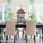 Dining room with dark wood table, cream upholstered chairs, and patterned accent chairs.