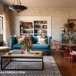 Turquoise sofa with patterned pillows, wooden coffee table, and ornate armchair in a living room.