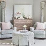 Living room with two light blue armchairs, pink pillows, and a tufted ottoman.
