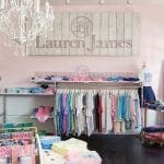 Retail store interior with clothing racks and a 'Lauren James' sign above.