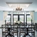Dining room with dark bamboo chairs, dark wood table, and crystal chandelier.