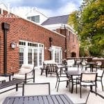 Brick building with patio seating and outdoor dining tables.