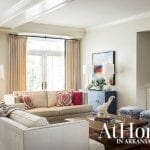Living room with beige sofas, patterned pillows, blue cabinet, and elephant statue