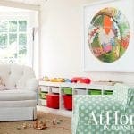 Playroom with white tufted armchair, green polka dot chair, and toy storage unit.