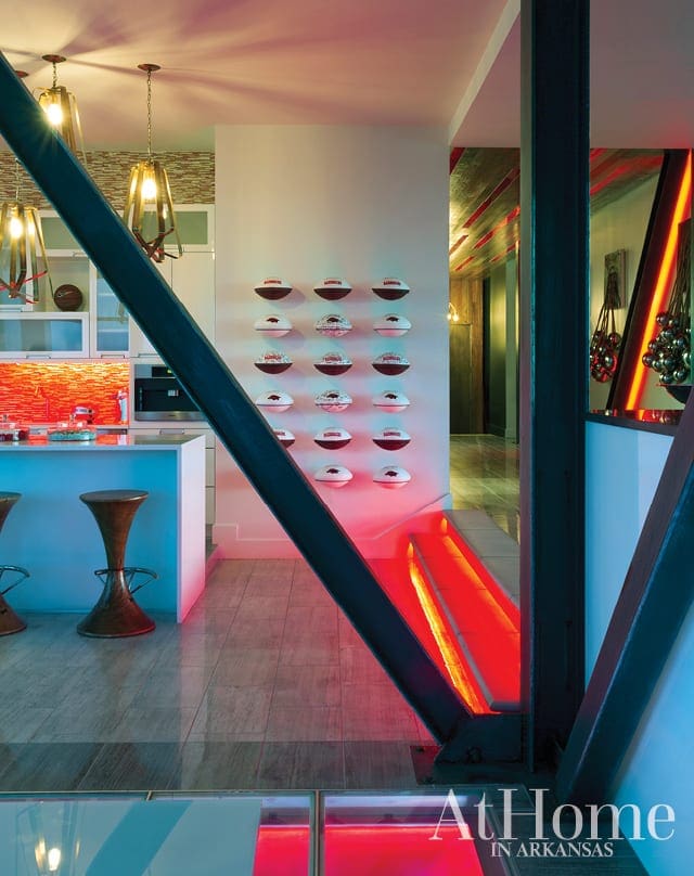 Modern kitchen with white island, pendant lights, and red backsplash. Industrial beams and red