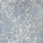 Close-up of marbled pattern in blue and cream with organic, web-like veins.